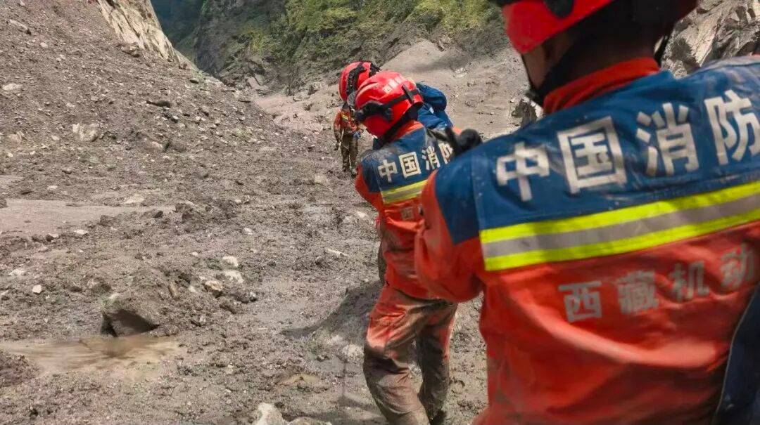 足球外围买球网站_西藏泥石流灾害现场沿岸树枝挂满裹着泥浆的衣物足球外围买球网站，救援最新画面：淤泥没过膝盖